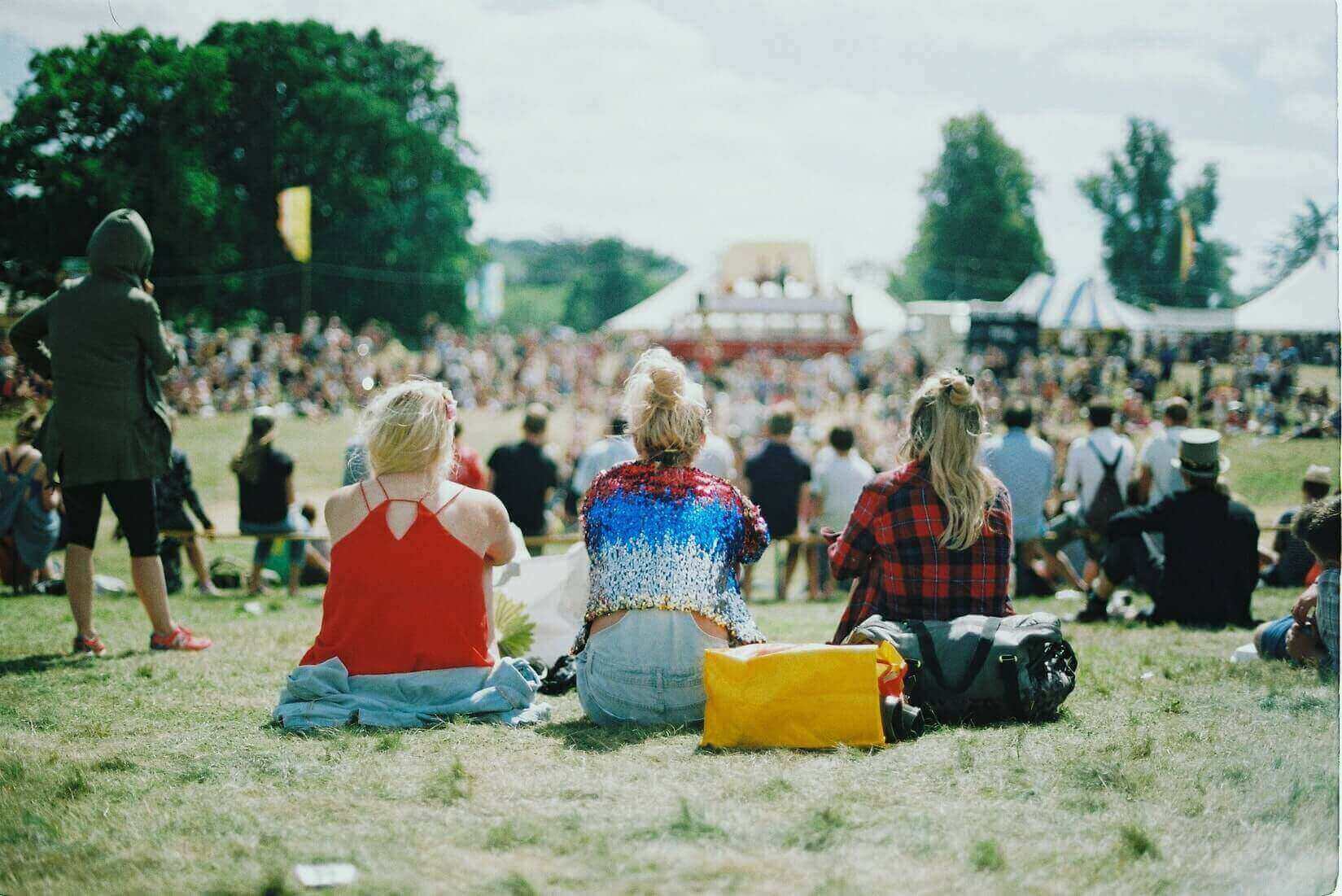 People sitting on the ground at a festival